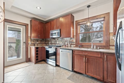 Modern kitchen featuring wood cabinetry and stainless steel appliances.