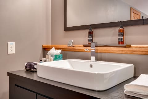 Modern bathroom sink with a stylish white square basin and dark wooden countertop.