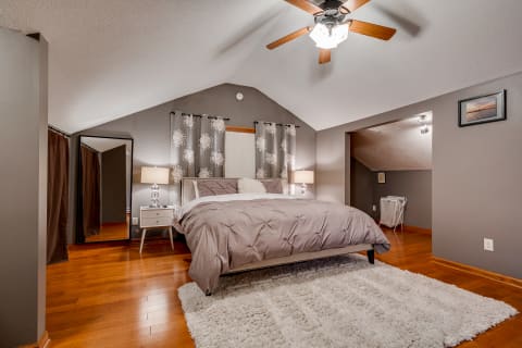 Cozy bedroom with a plush bed, warm wood floors, and elegant decor.