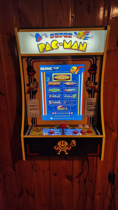 Arcade cabinet for 'Super Pac-Man' with game selection screen and controls.