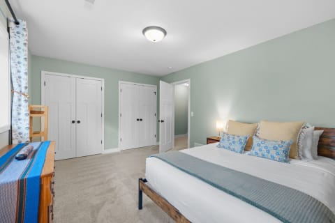 A serene bedroom featuring a bed with decorative pillows and a warm atmosphere.