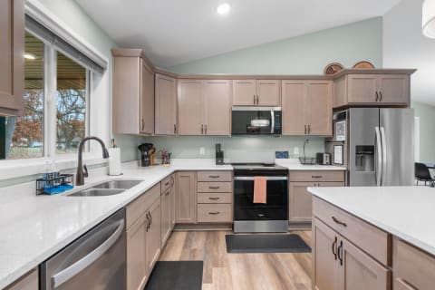 Interior view of a modern kitchen with wooden cabinets and white countertops.