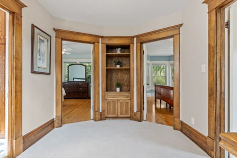 A cozy corner nook featuring a built-in cabinet with wood trim and two doorways leading to other rooms.
