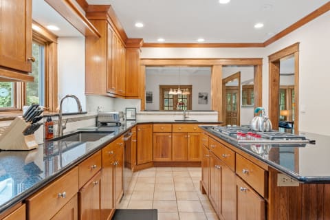 Modern kitchen with wooden cabinets, granite countertops, and sleek appliances.