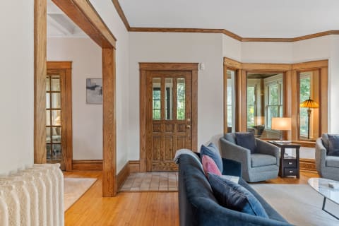 A cozy living room with plush seating, wooden accents, and natural light from windows.