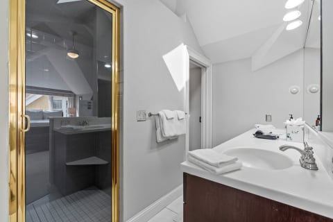 A spacious bathroom with a walk-in shower, decorative toiletries, and modern fixtures.