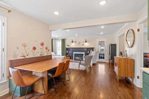 Cozy open-concept dining and living space with a floral wall mural and modern furniture.