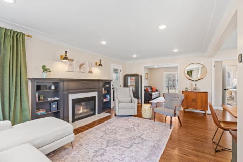 Cozy living room featuring a fireplace, comfortable seating, and modern decorations.