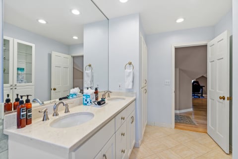 Bright modern bathroom with double vanity and blue walls.