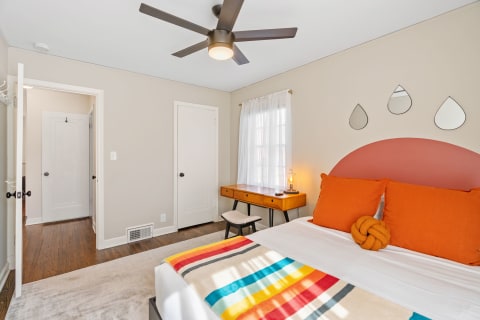 Interior view of a cozy bedroom featuring a colorful bedspread and modern decor.