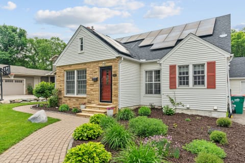 Front view of a house featuring a landscaped garden and solar panels.