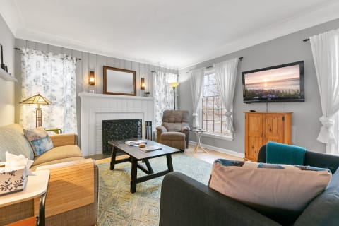 Cozy living room with gray walls, fireplace, and comfortable furniture.