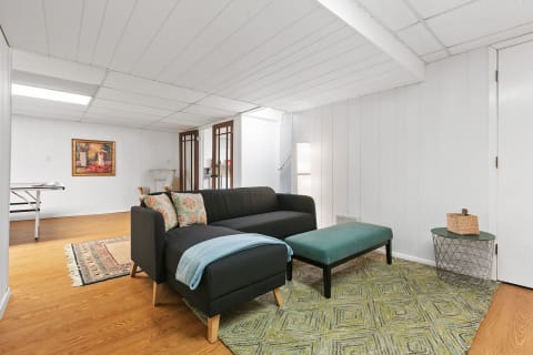 Living room featuring a sectional couch, decorative pillows, and a geometric rug.
