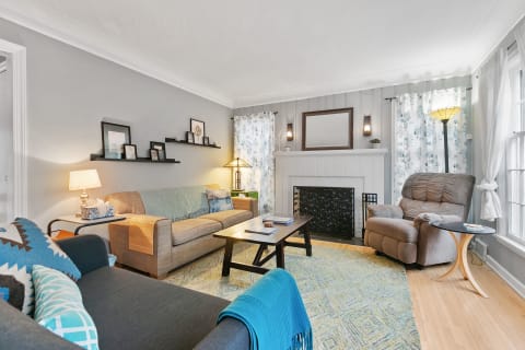 Inviting living room featuring a combination of gray walls, wooden flooring, and comfortable seating.