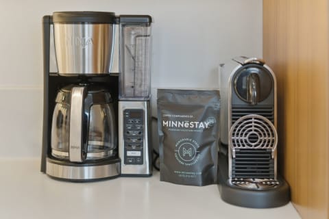 A Ninja coffee maker and espresso machine next to a bag of MinneStay coffee on a countertop.