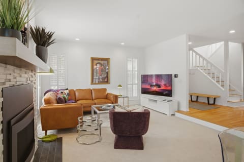 A cozy living room featuring a leather sectional, modern TV, and stylish decor.
