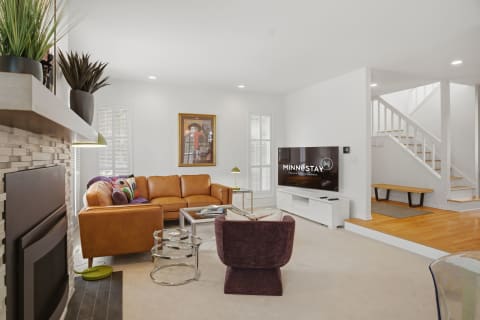 Bright modern living room featuring leather seating, stylish decor, and a fireplace.
