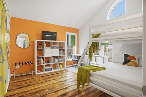 Children's bedroom with orange accent wall and bunk bed