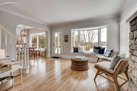 A bright and airy living room with hardwood flooring, a cozy seating area, and large windows.