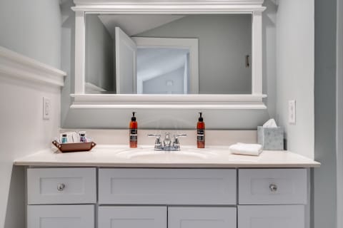 Modern bathroom vanity with stylish accessories and a large mirror.