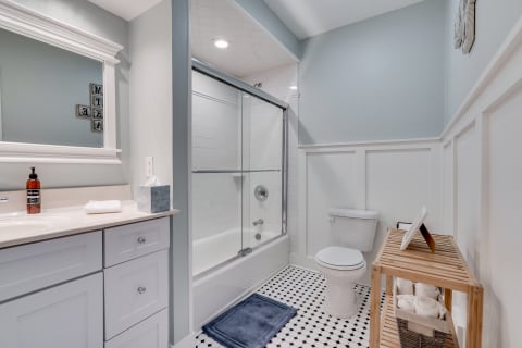 Interior shot of a modern bathroom with a glass shower and white vanity.