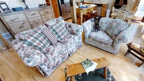 A living room with floral sofas and a wooden coffee table on a rug.