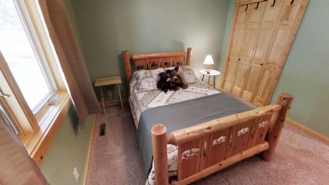 Cozy bedroom with a wooden bed, patchwork quilt, and plush bears.