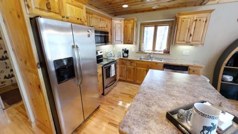 A modern kitchen featuring stainless steel appliances and rustic wooden cabinets.