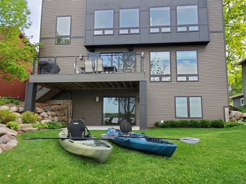 Modern house with large windows and kayaks in the foreground.