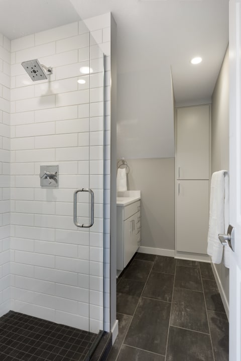 A contemporary bathroom with a glass shower and white vanity.