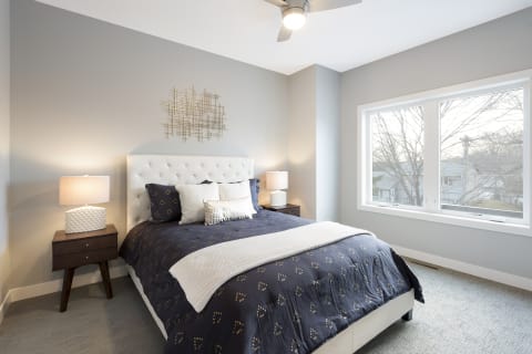 Cozy bedroom featuring a navy blue comforter, white headboard, and contemporary decor.