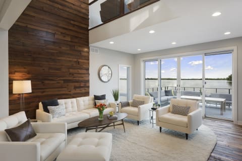 Modern living room featuring a lake view through large glass sliding doors.