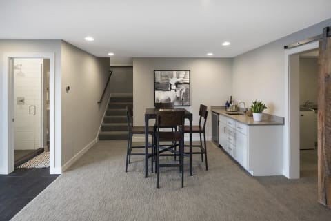 Stylish lower-level room featuring dining space and kitchenette.