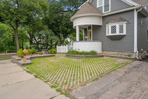 Gray house with white trim and unique eco-friendly driveway.