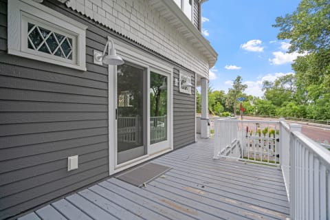 Exterior of a house featuring a porch with a glass door and decorative window.