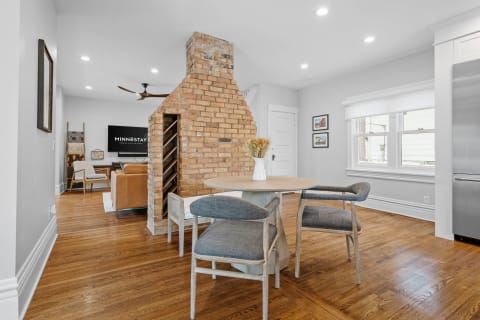 A stylish interior featuring a dining table and a living area with a brick chimney.