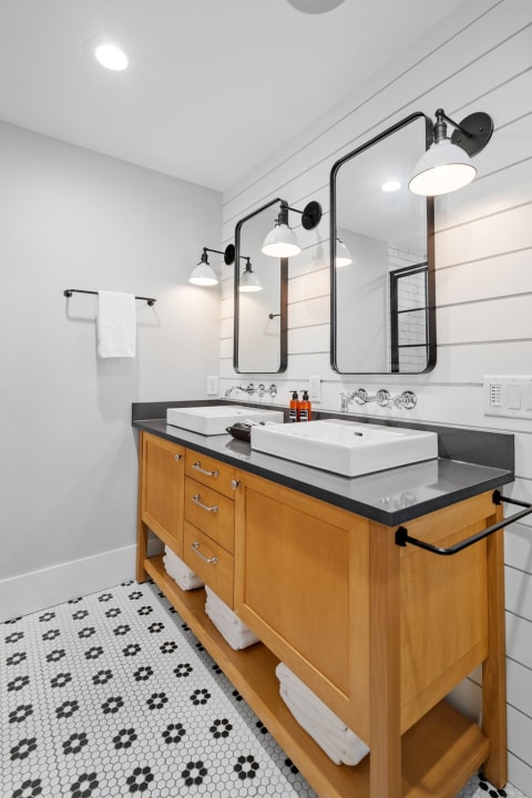Modern bathroom featuring a wooden sink vanity and stylish decor.