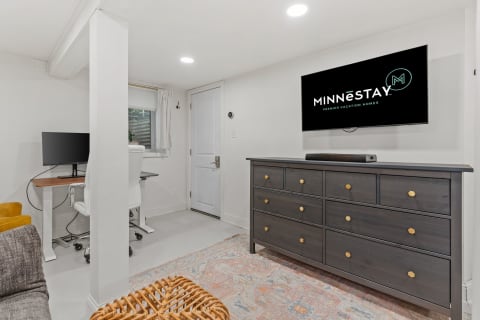 Modern living space with a sofa, desk, and TV.