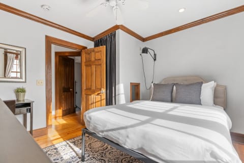 Cozy bedroom with a bed, decorative pillows, and warm wood finishes.
