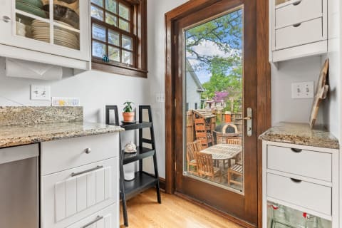 Interior view of a kitchen with granite countertops leading to a backyard patio.