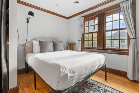 Cozy bedroom with a bed, window, and wooden accents.