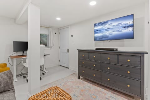 Modern basement interior with workspace and cozy seating area.