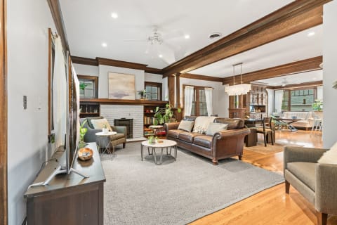 Cozy living room with leather sofa, green armchair, and a white brick fireplace.