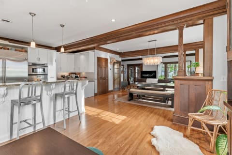Open-concept kitchen and living area with white cabinetry and hardwood floor.