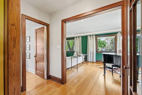An interior image with hardwood trim and vibrant green walls, showcasing a welcoming entry into a stylish living area.
