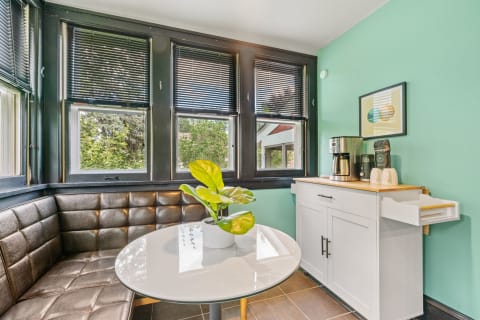Bright breakfast nook featuring leather seating and a coffee station, with views outside.