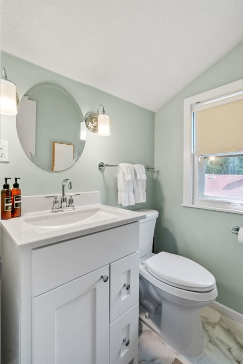Inviting bathroom featuring mint green walls, modern fixtures, and warm light.