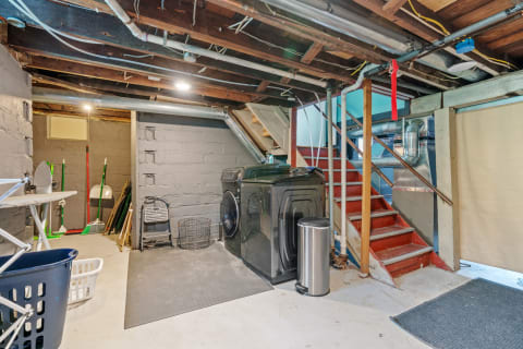 Basement utility area with washer, dryer, and cleaning supplies.