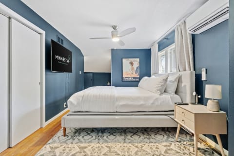 Bedroom with blue walls, queen bed, and contemporary decor.