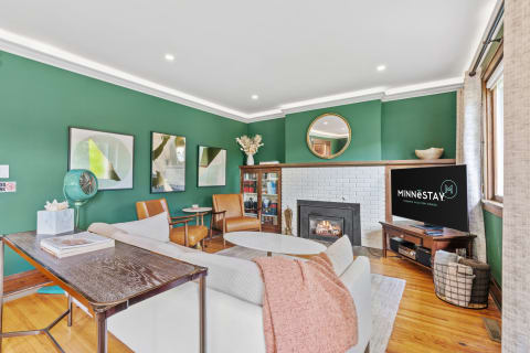 Stylish living room with emerald walls, cozy fireplace, and modern decor elements.